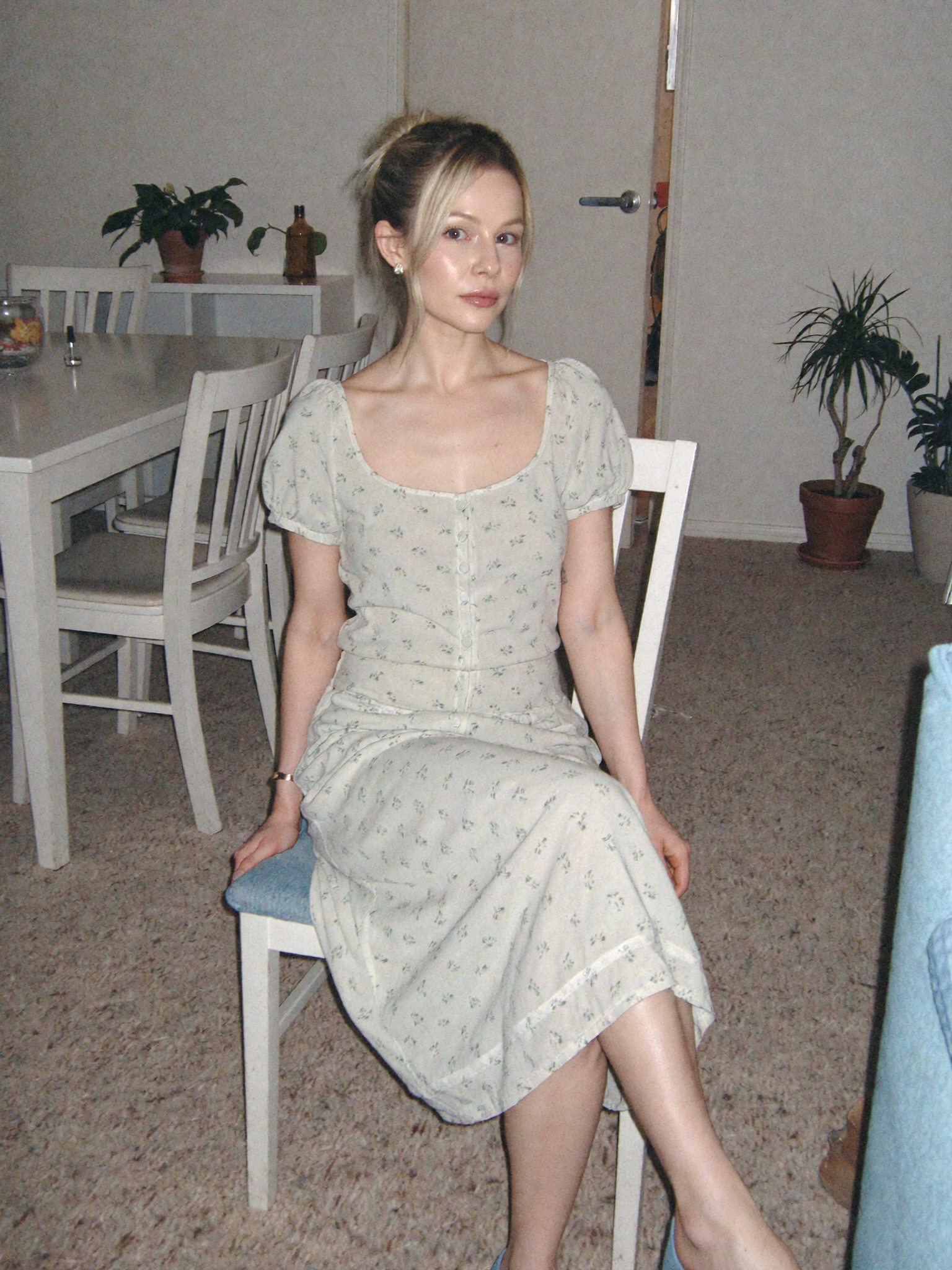 Seated portrait in floral sundress with soft interior light
