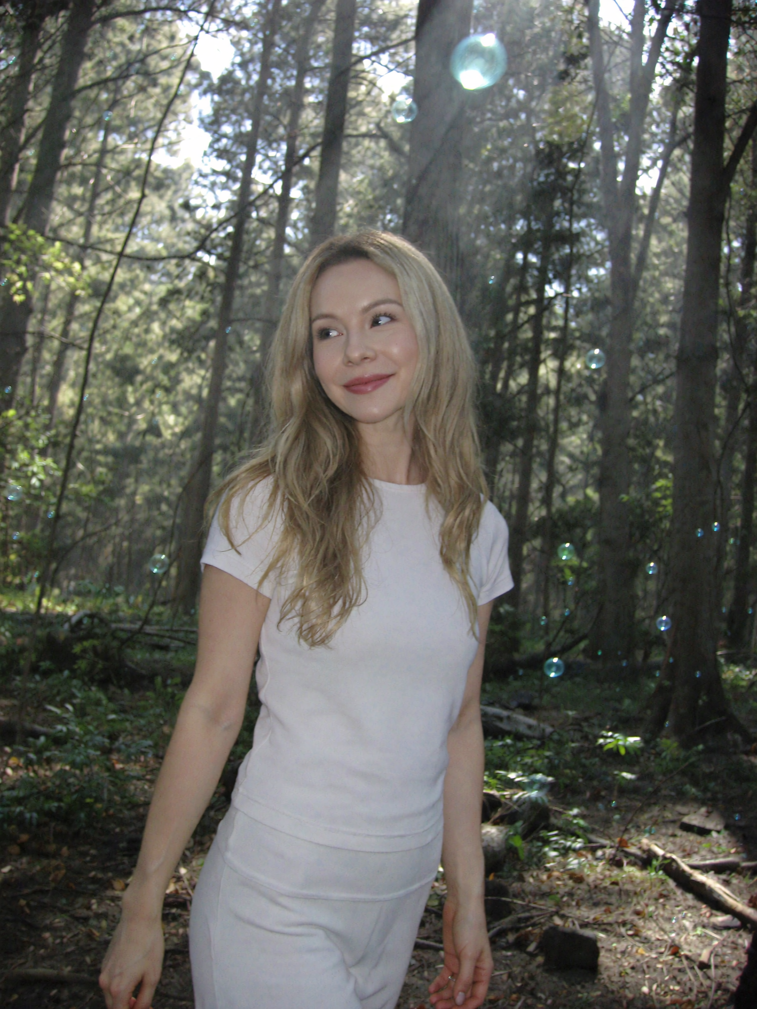 Natural light portrait in forest with soft bubbles